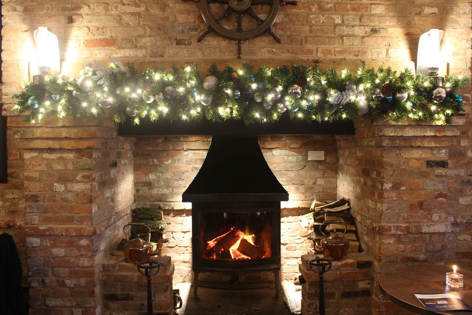 Garlanded fireplace with a lit wood burner in a country home