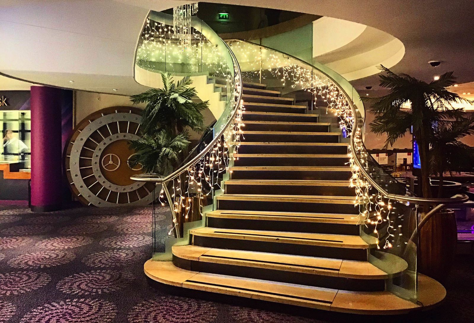Sweeping staircase dressed with cascading fairy lights at an event venue