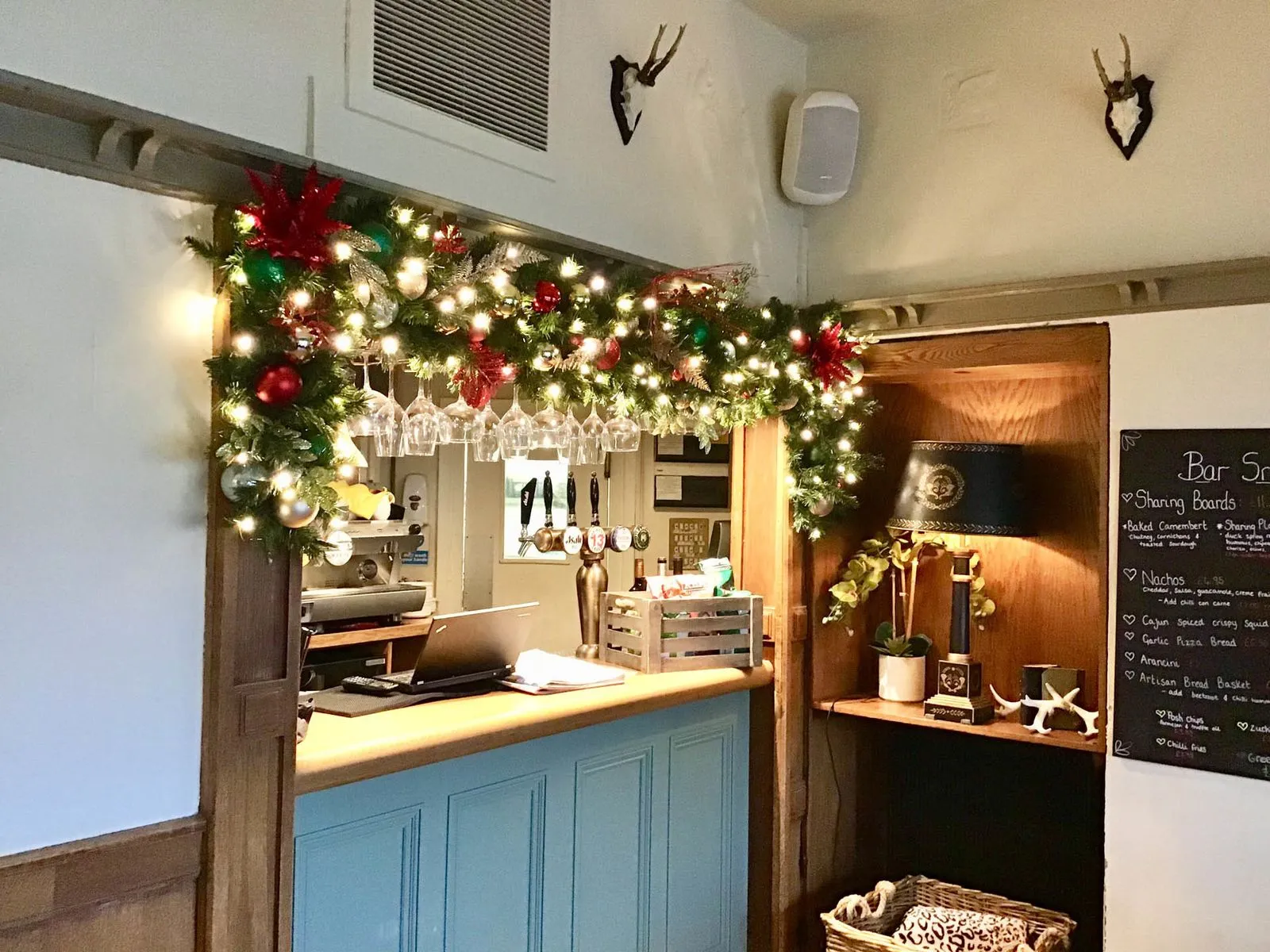 Bar servery dressed with a lit garland of red baubles