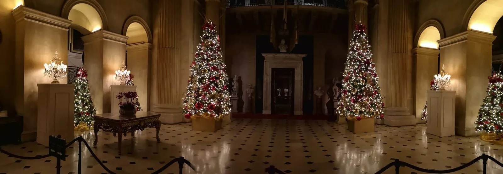 Christmas trees lining a grand marble hall