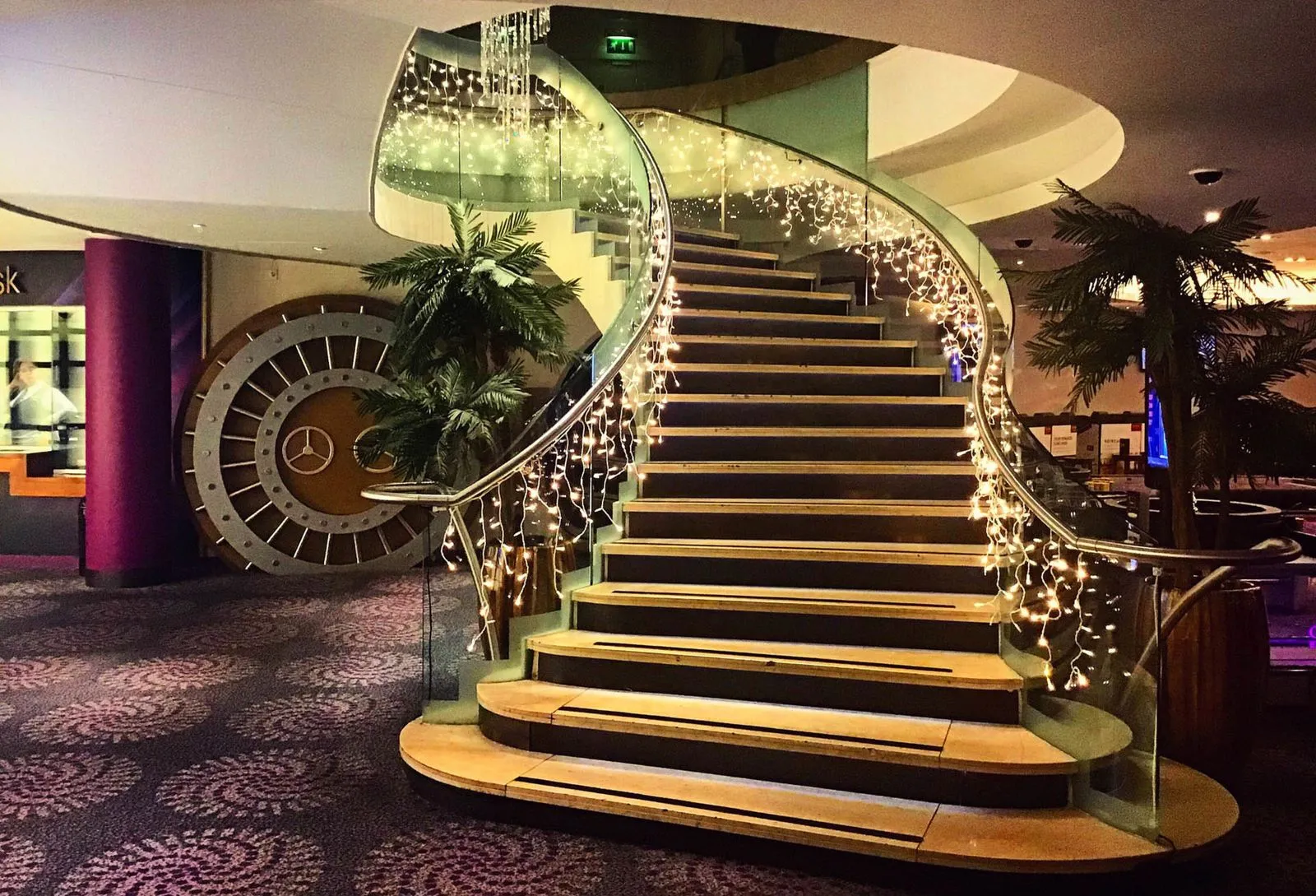 Sweeping staircase dressed with cascading fairy lights at an event venue