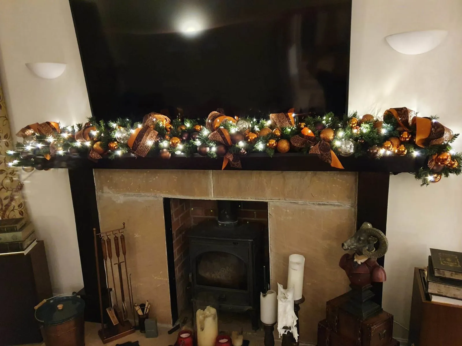 Lit Christmas garland above a log burner